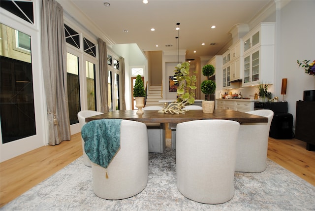 dining area featuring ornamental molding and light hardwood / wood-style flooring