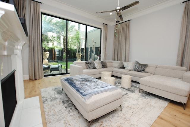 living room with ceiling fan, ornamental molding, and light wood-type flooring