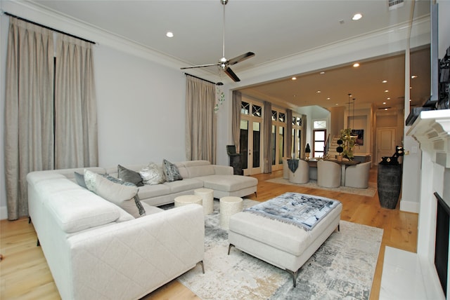 living room featuring crown molding, light hardwood / wood-style flooring, and ceiling fan