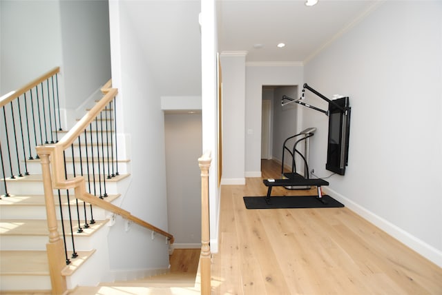 exercise area with light hardwood / wood-style floors and crown molding