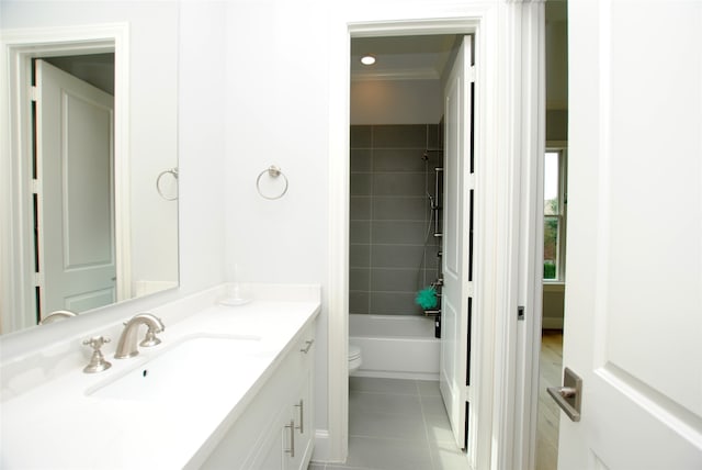 full bathroom featuring vanity, tile patterned flooring, crown molding, toilet, and tiled shower / bath combo