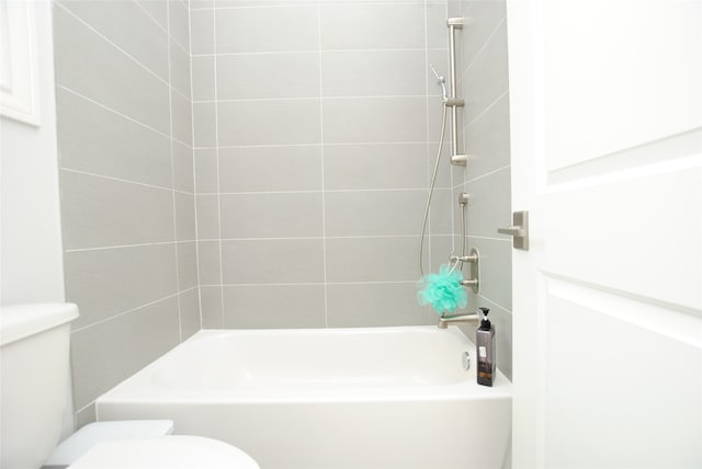 bathroom featuring toilet and tiled shower / bath combo