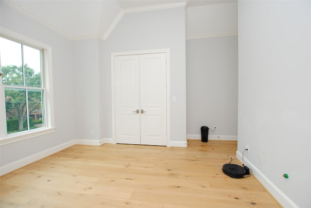 clothes washing area with light hardwood / wood-style flooring, crown molding, and a healthy amount of sunlight