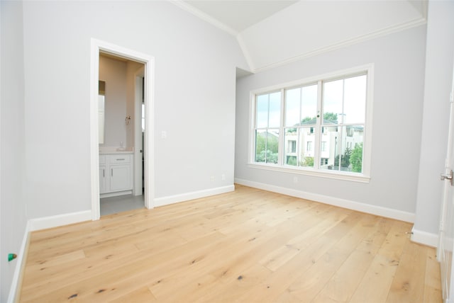 interior space featuring crown molding, lofted ceiling, and light hardwood / wood-style flooring