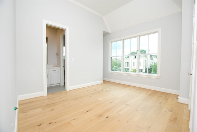 unfurnished bedroom featuring lofted ceiling, light hardwood / wood-style floors, and crown molding