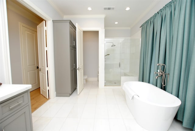 full bathroom featuring vanity, separate shower and tub, toilet, ornamental molding, and tile patterned floors