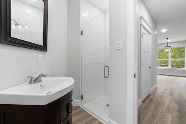 bathroom featuring a shower with shower door, hardwood / wood-style floors, and vanity