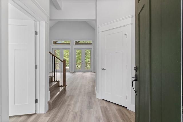 hallway with light wood-type flooring and vaulted ceiling