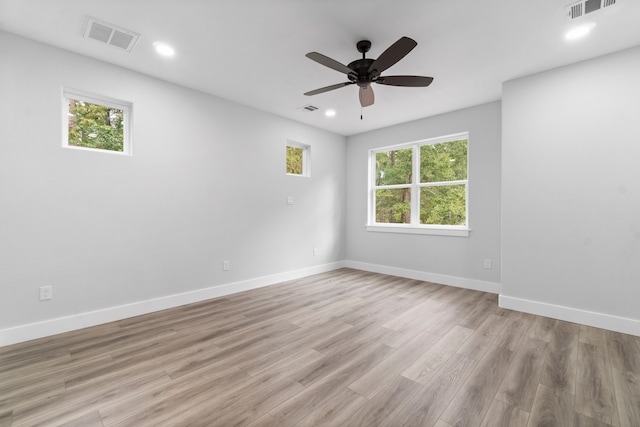 spare room with a healthy amount of sunlight, ceiling fan, and light hardwood / wood-style floors