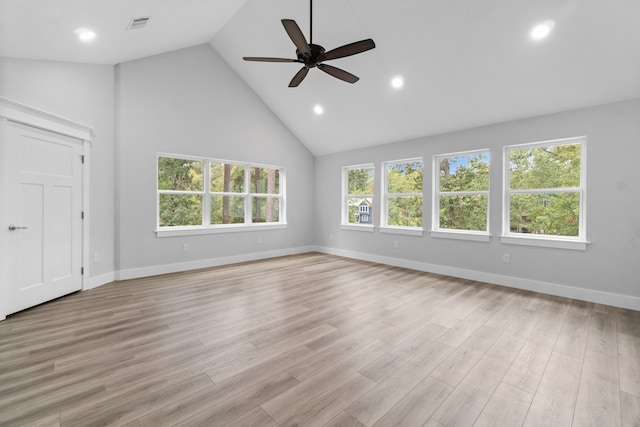 unfurnished living room with high vaulted ceiling, a wealth of natural light, light hardwood / wood-style flooring, and ceiling fan