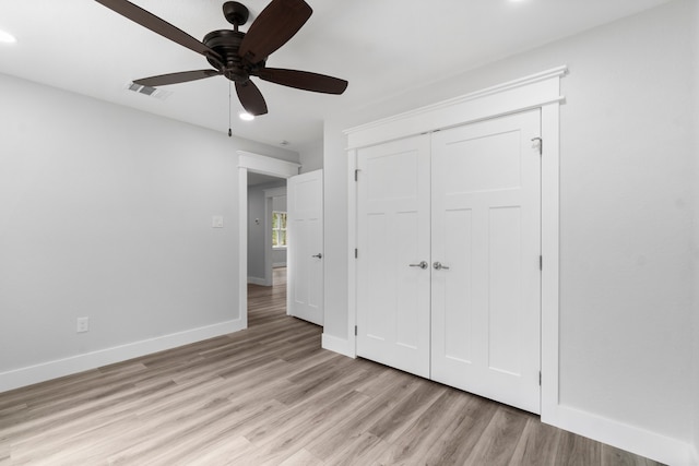 unfurnished bedroom featuring light hardwood / wood-style flooring, ceiling fan, and a closet