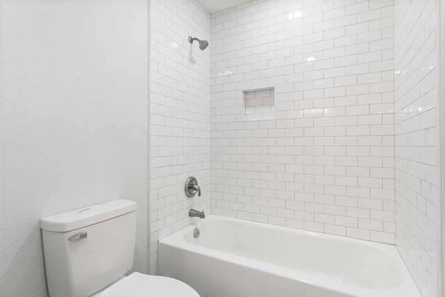 bathroom with tiled shower / bath and toilet