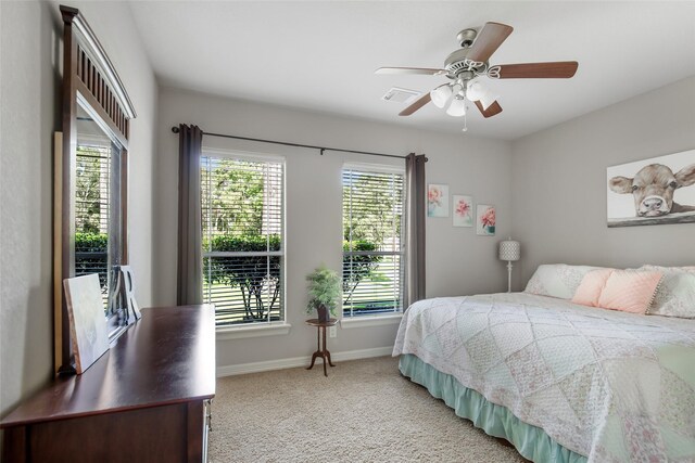 carpeted bedroom with multiple windows and ceiling fan