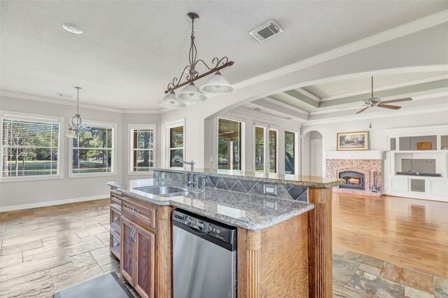 kitchen with ceiling fan, sink, pendant lighting, dishwasher, and an island with sink