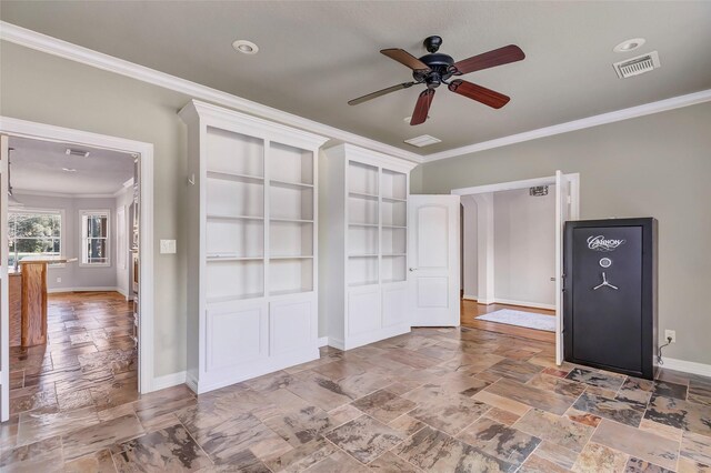 empty room with ceiling fan, built in features, and ornamental molding