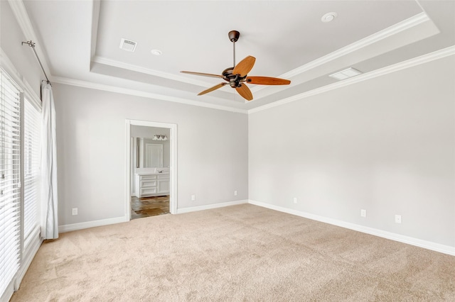 unfurnished bedroom featuring ceiling fan, a raised ceiling, light colored carpet, and crown molding