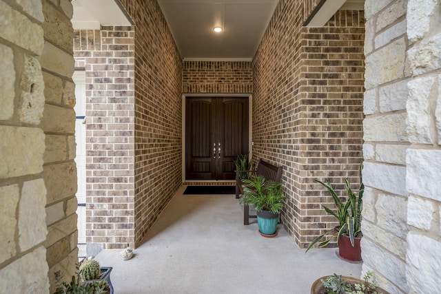 view of exterior entry featuring brick siding