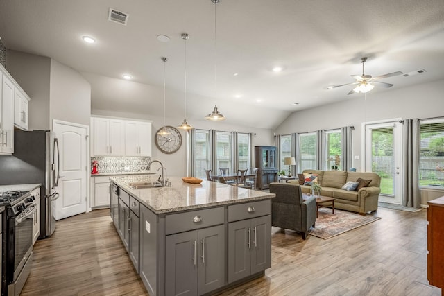 kitchen with tasteful backsplash, visible vents, gray cabinetry, appliances with stainless steel finishes, and a sink