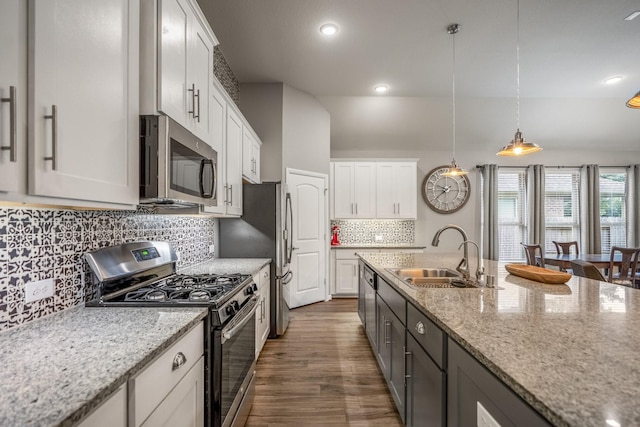 kitchen featuring light stone counters, stainless steel appliances, dark wood-type flooring, white cabinetry, and a sink