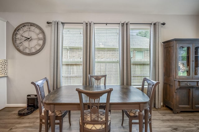 dining area featuring light wood-style floors and baseboards