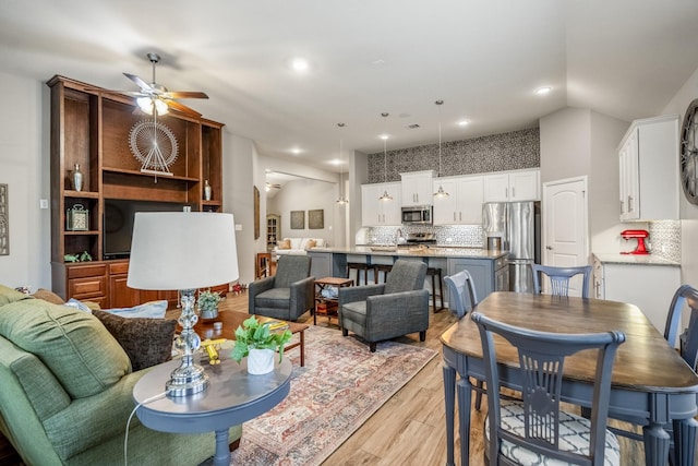 living room featuring light wood-style floors, recessed lighting, vaulted ceiling, and ceiling fan