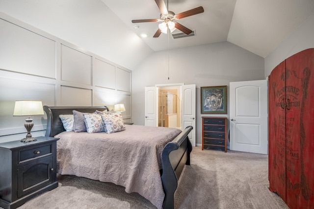 bedroom with visible vents, connected bathroom, light colored carpet, vaulted ceiling, and a decorative wall