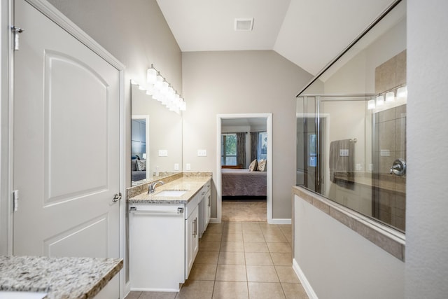 full bath with ensuite bathroom, lofted ceiling, vanity, tile patterned floors, and walk in shower