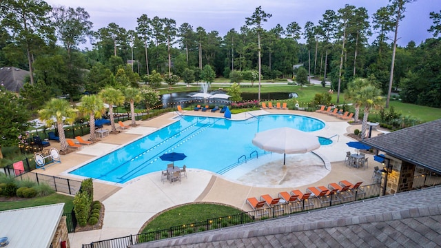 pool with a patio area and fence