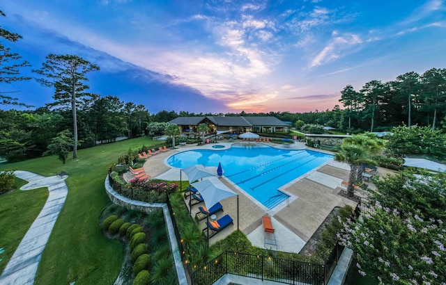 pool with a patio area and a lawn