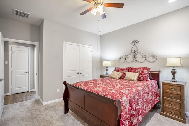 carpeted bedroom with a ceiling fan, a closet, visible vents, and baseboards