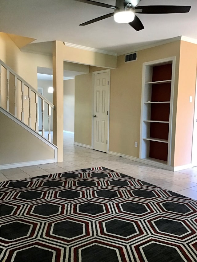 interior space featuring ornamental molding, built in shelves, and ceiling fan