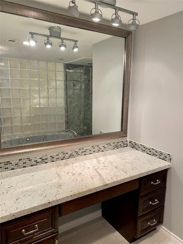 bathroom featuring vanity, tasteful backsplash, and a shower with shower door