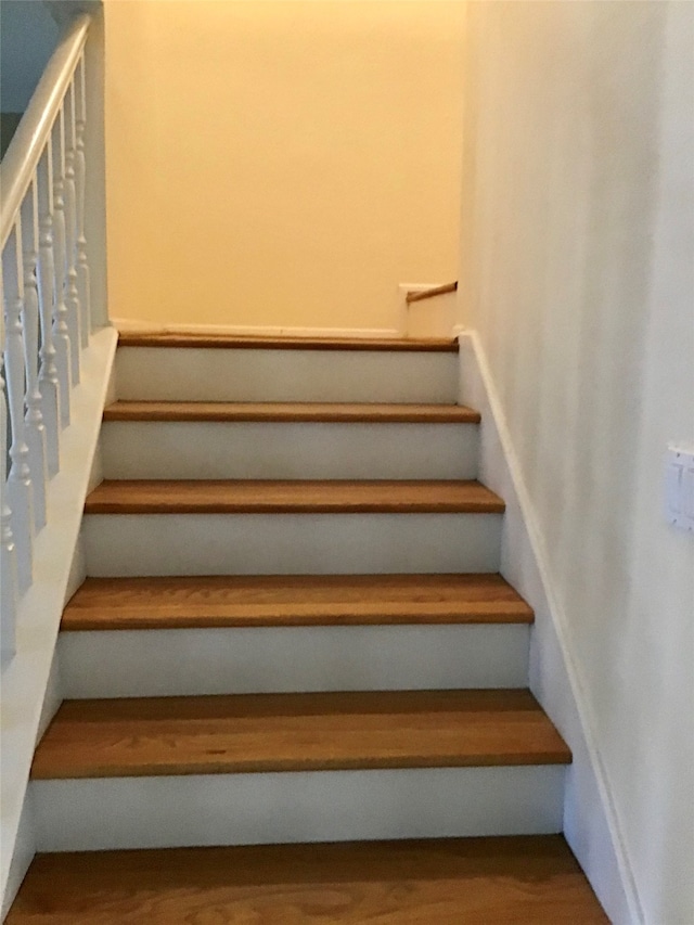 stairway featuring wood-type flooring