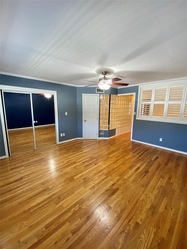 interior space with hardwood / wood-style floors, crown molding, and ceiling fan