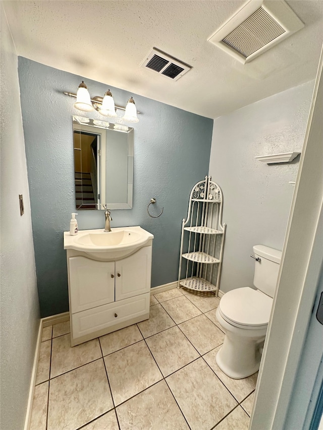 bathroom with vanity, toilet, and tile patterned flooring