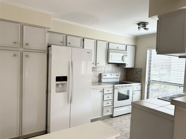 kitchen featuring decorative backsplash, light tile patterned floors, ornamental molding, gray cabinetry, and white appliances