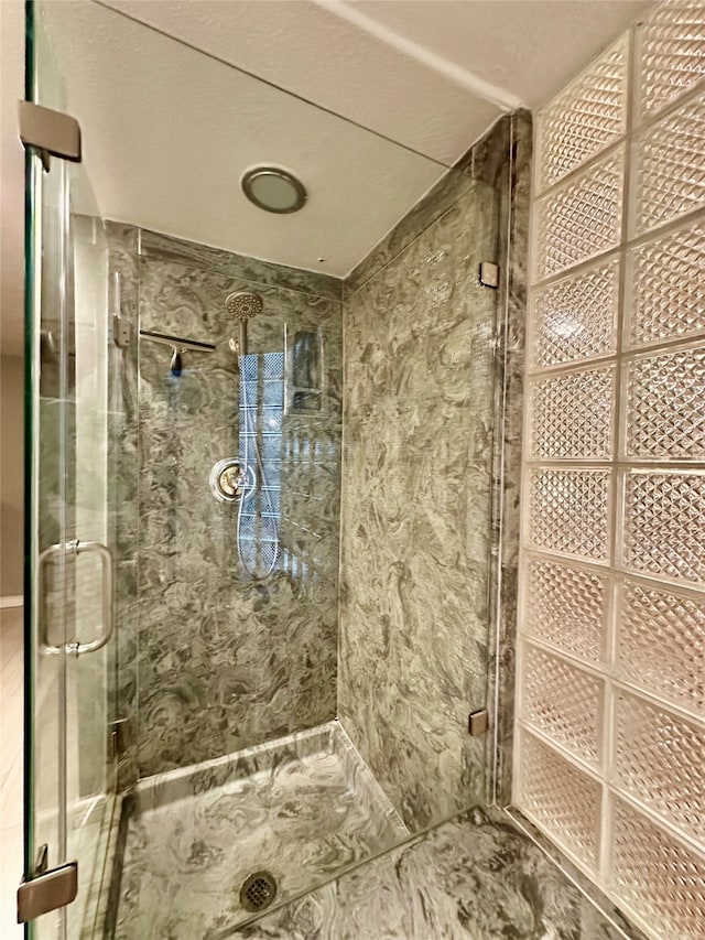 bathroom with a shower with door