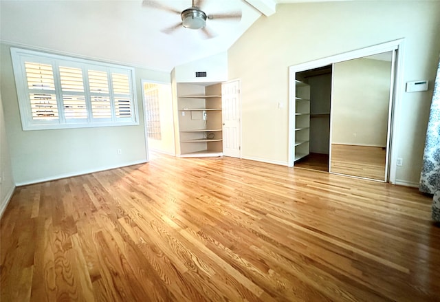 unfurnished bedroom featuring lofted ceiling with beams, wood-type flooring, two closets, and ceiling fan