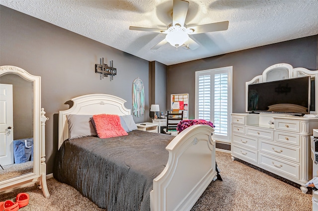 bedroom featuring a textured ceiling, light colored carpet, and ceiling fan