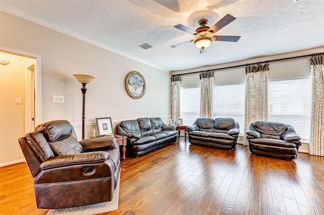 living room with ceiling fan, ornamental molding, wood-type flooring, and a textured ceiling