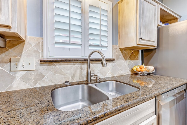 kitchen with dishwasher, sink, light brown cabinets, and light stone countertops