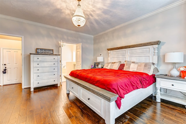 bedroom with crown molding, dark wood-type flooring, and ensuite bathroom