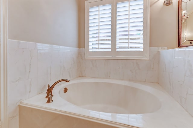 bathroom with a wealth of natural light and a relaxing tiled tub