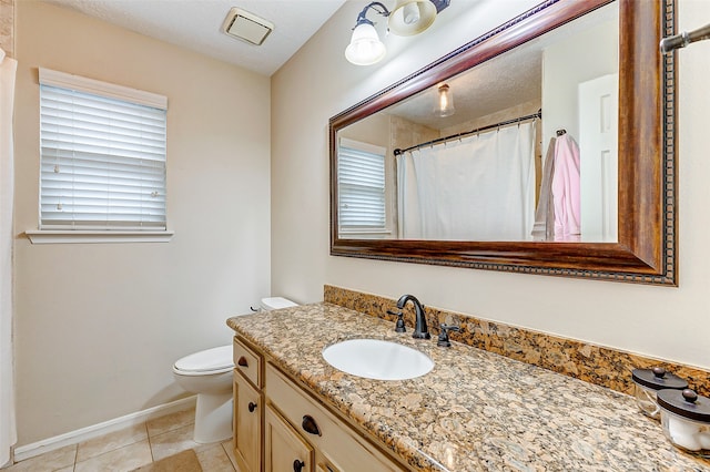 bathroom featuring vanity, toilet, a textured ceiling, and tile patterned flooring