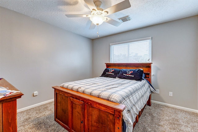 carpeted bedroom featuring ceiling fan and a textured ceiling