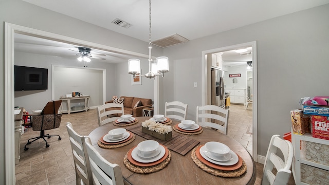 dining area featuring ceiling fan with notable chandelier