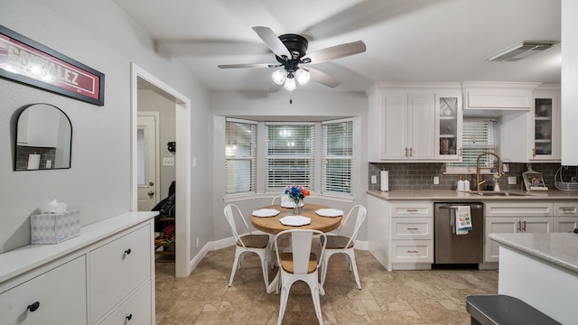 kitchen with backsplash, white cabinets, ceiling fan, sink, and dishwasher