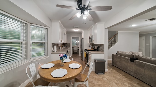 dining room with ceiling fan, ornamental molding, and sink