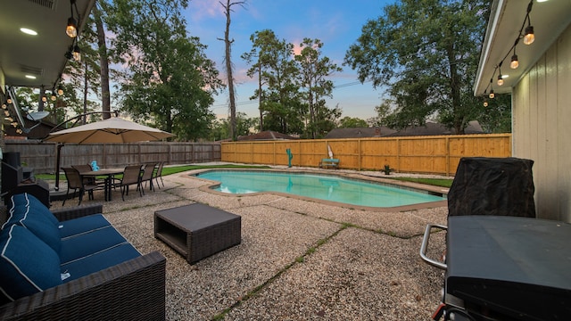 pool at dusk featuring a patio