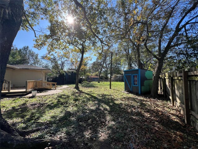 view of yard with a wooden deck and a storage unit